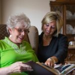Senior woman and younger woman looking at a photo album
