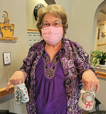 Senior woman holding decorated jars