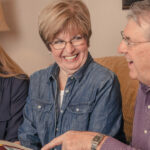Senior couple talking with sales director about senior living finance options
