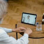 Senior man talking to his clinician virtually on his tablet.