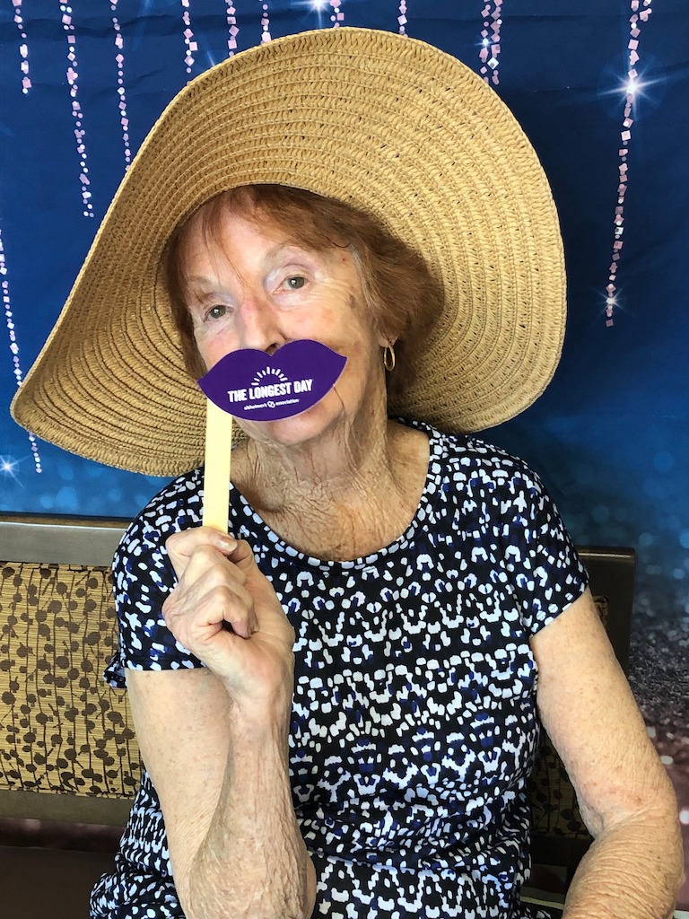 Primrose resident sitting on chair wearing hat at the Longest Day annual event.