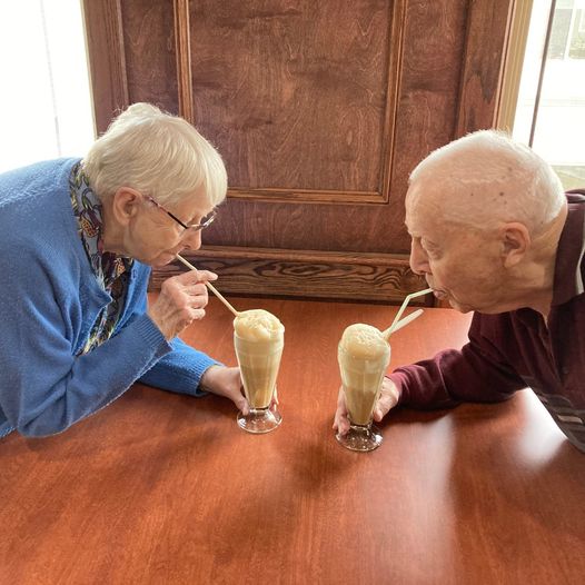 Two seniors enjoying a fresh milkshake at a Primrose cafe.