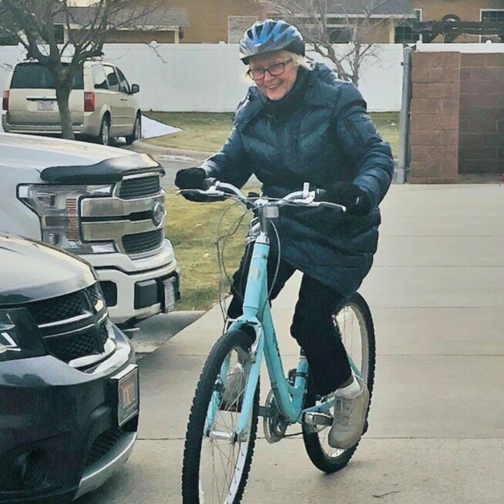 Senior woman riding a bike wearing a coat and helmet