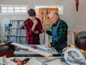 Grandfather with teenage grandson in the workshop