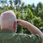Senior male veteran saluting the United States flag