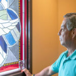 Senior man reflecting at the chapel stained-glass window