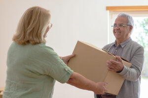 Senior couple passing a box that is packed for moving