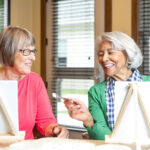 Two senior women enjoying a painting activity