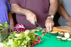 Residents cutting vegetables during a cooking demonstration