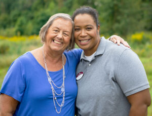 Senior female resident enjoying a walk outdoors with a staff member