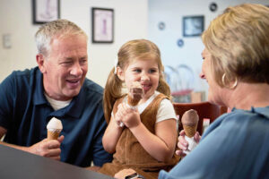 Senior couple with granddaughter having ice cream at an ice cream social