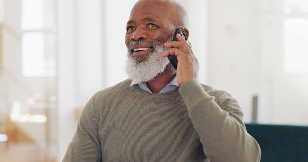 A senior man is on the phone with someone he met on a dating app.